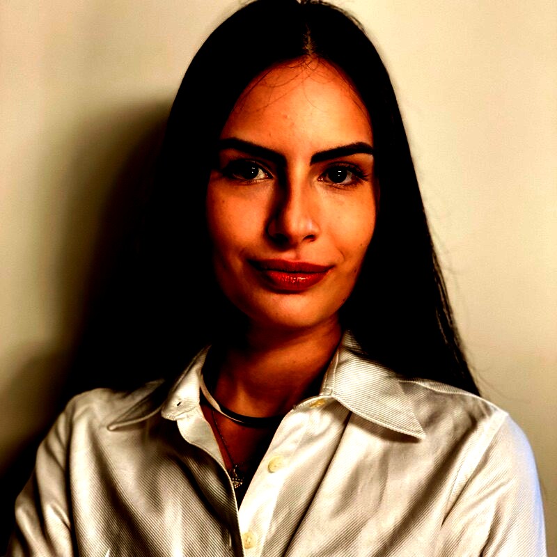 Júlia Castellari Ribeiro, corporate and M&A lawyer, in a warm editorial portrait.